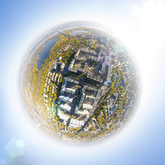 Aerial city view with crossroads, roads, houses, buildings, parks and parking lots, bridges. Copter shot. Little planet mode.