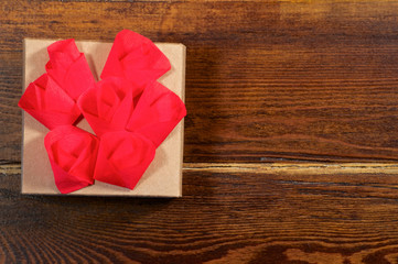 Red flowers over gift box close up