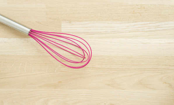 Pink Whire Wisk On Wooden Kitchen Table