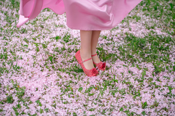 Feet of small girl on grass with petals © Volodymyr