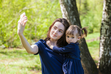 Mom and daughter on a walk in the summer park