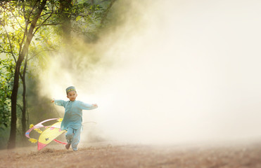 Little muslim boy running with kite.Scene of early morning with heavy fog.Soft focus and copyspace...