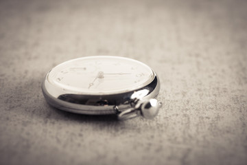 Old pocket watch on stone table. Symbol of time, deadline and nostalgia.