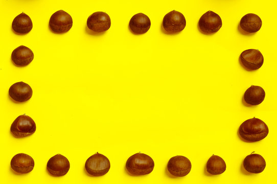 Chestnuts pattern on yellow background top view chestnut