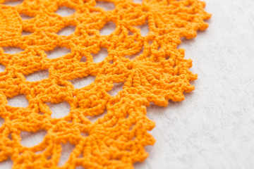 Vintage crochet tablecloth on table. Handmade needlework. Picture of retro textile decoration. Background of traditional romantic and decorative cloth.