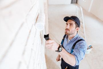 Close-up portrait of a decorator using roller during work