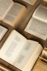 Libros abiertos sobre una mesa de madera rústica. Vista superior y de cerca. Formato vertical