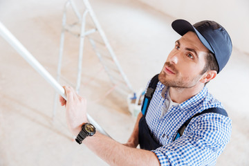 Obraz premium Close-up portrait of a decorator using roller in work