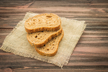 Slices of rye bread on a wooden background