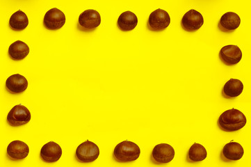 Chestnuts pattern on yellow background top view chestnut