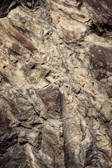 Stone background, rock wall backdrop with rough texture. Abstract, grungy and textured surface of stone material. Nature detail of rocks.