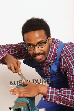 Junger Mann feilt an dem Wort "Ausbildung, Symbolfoto zum Thema Ausbildung