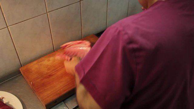 Butcher Cutting Back Part Of Cow