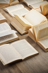 Obraz premium Libros de lectura abiertos sobre una mesa de madera rustica. Vista superior y de cerca. Formato vertical