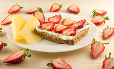 Bread with strawberry, cheese, strawberry on table