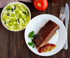 Juicy piece of roast goose on a white plate.The top view
