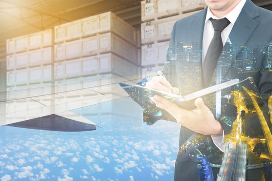 Double exposure of business man analyzing report and business center city with blurred cargo in wooden case at warehouse and export plane aeriel background, exportation and trading concept