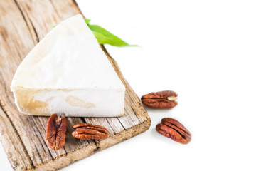 Fototapeta na wymiar Cheese with white mold and pecan nut on a white background