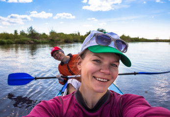 Young woman doing selfie on kayak in beautiful nature. Summer sunny day