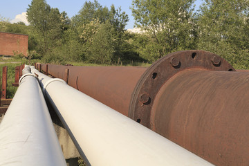 Rusty steel pipelines in grass field