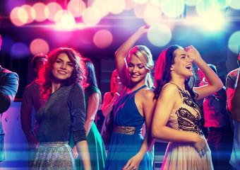 smiling friends dancing in club