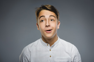 Closeup Portrait of happy boy going surprise isolated on gray background