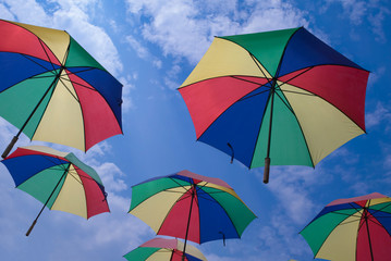 Colorful umbrellas hanging over head with cloud and sky background
