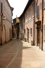 Lane in Urbino, with small street and little buildings of red bricks, Italy