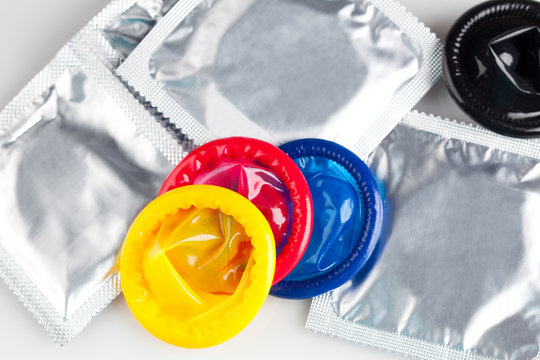 Couple of Colorful condoms with packaging, isolated on white