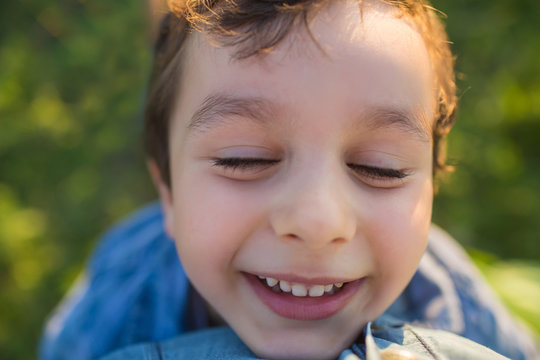 Portrait of a smilling cute little boy wiht closed eyes (tilt view)