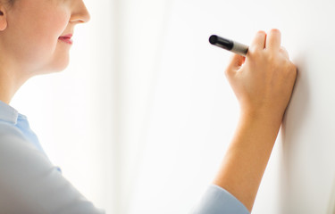 close up of woman writing something on white board