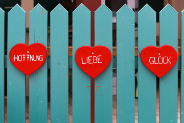Hope, Love, Happiness - three red heats on wooden fence