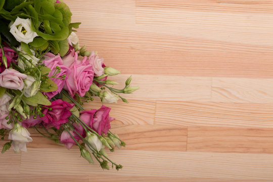 Closeup image of bouquet of flowers of white or pink roses represented on wooden background. Wedding or Valentine's concepts.