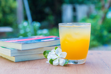 Glass of juice and books on the wooden table