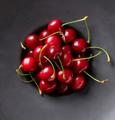 Obraz na płótnie Canvas black bowl full of cherry , from above