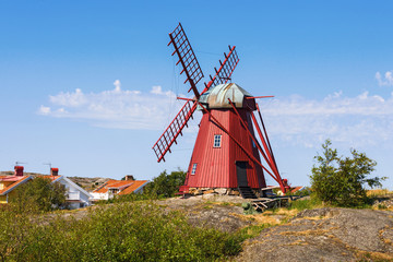 Wooden Windmill on the rocks on a summer day
