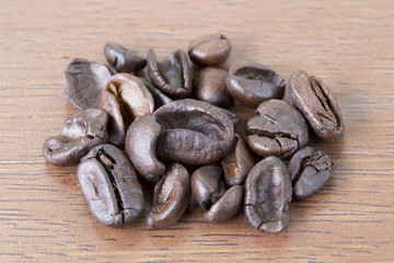 Low quality not good coffee bean on wooden table.