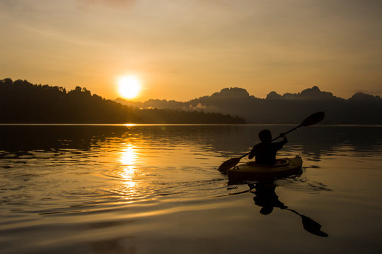 Silhouette man kayaking