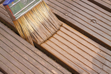 Decking painting staining / Painting staining decking in a garden - obrazy, fototapety, plakaty