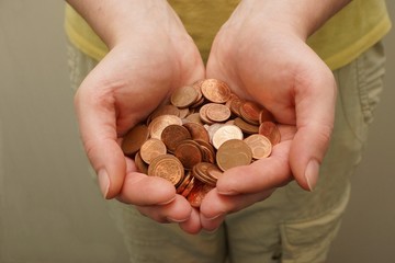 Many euro cent coins in woman hand