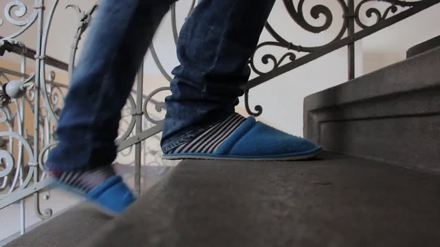 Man in slippers goes up to stairs