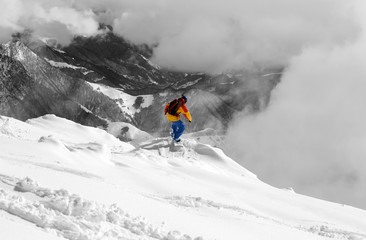 Naklejka na ściany i meble Snowboarder on off-piste slope an mountains in fog. Selective co