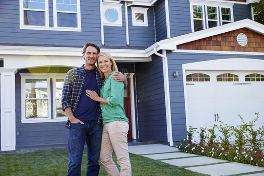 Portrait Of Couple Standing Outside House