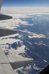 Swiss Alps and Clouds Aerial View from Airplane porthole