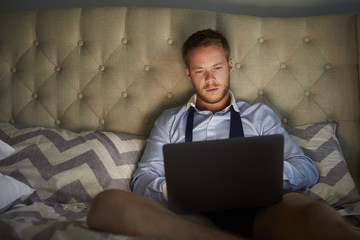 Businessman At Home On Bed Working Late On Laptop