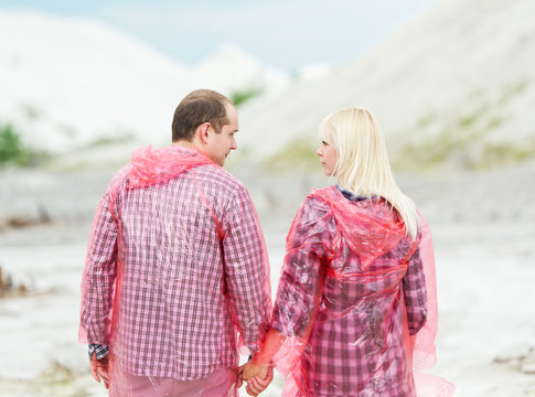 The woman and the man in protective raincoats.