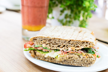 Sandwich serviert with smoothie on wooden table.