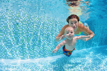 Child swimming lesson - baby with mother learn to swim, dive underwater in swimming pool. Healthy...