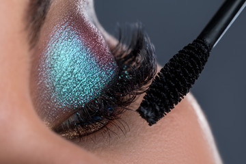 Female eye with long lashesh and mascara brush