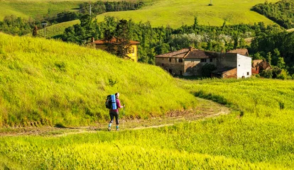 Cercles muraux Toscane female hiker walking across tuscany hills